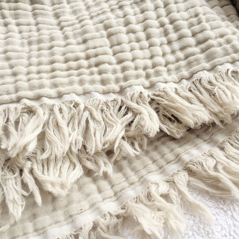 KyraHome muslin blanket folded in oatmeal khaki for cozy display.
