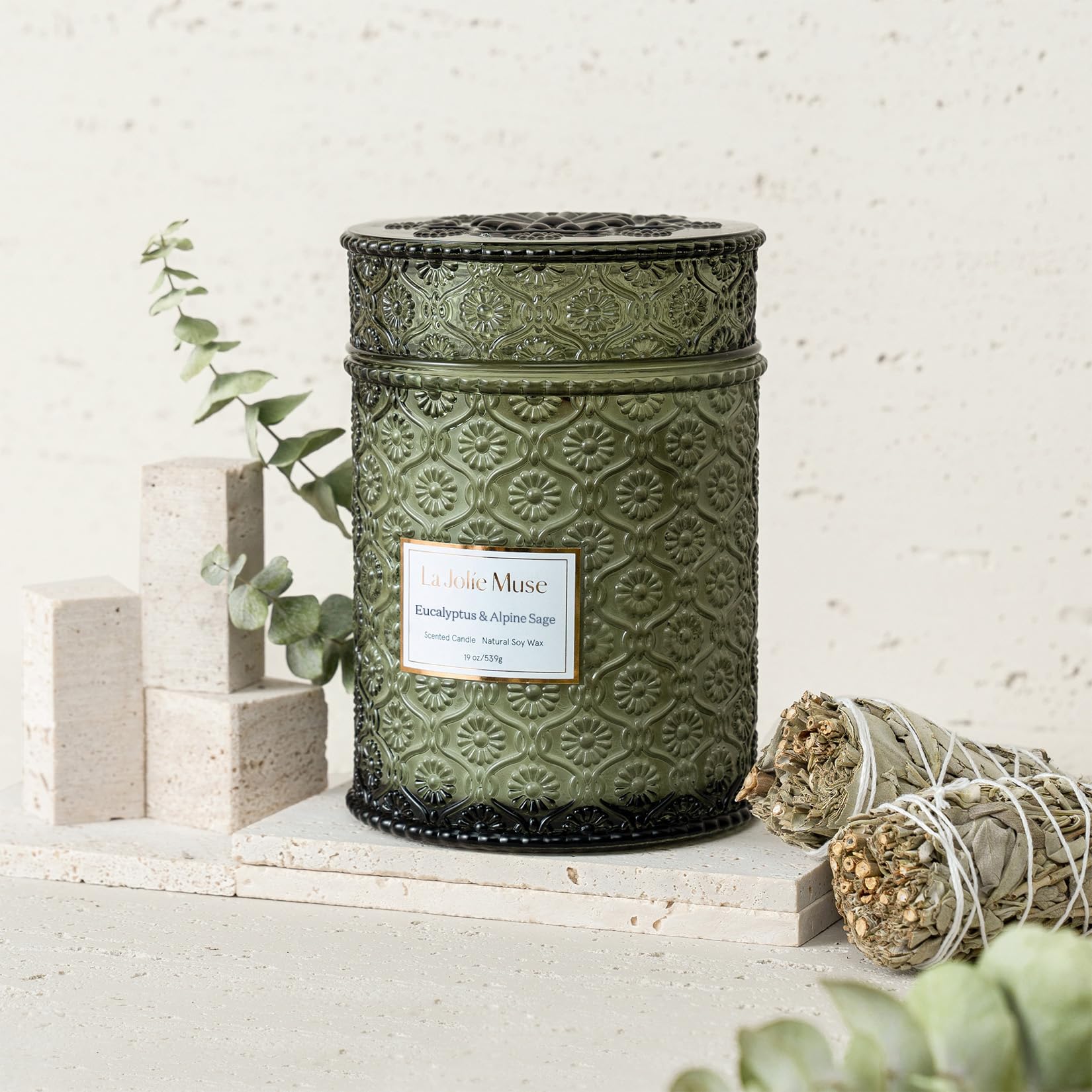 LA JOLIE MUSE embossed daisy jar showcases elegant décor alongside luxurious fragrance.