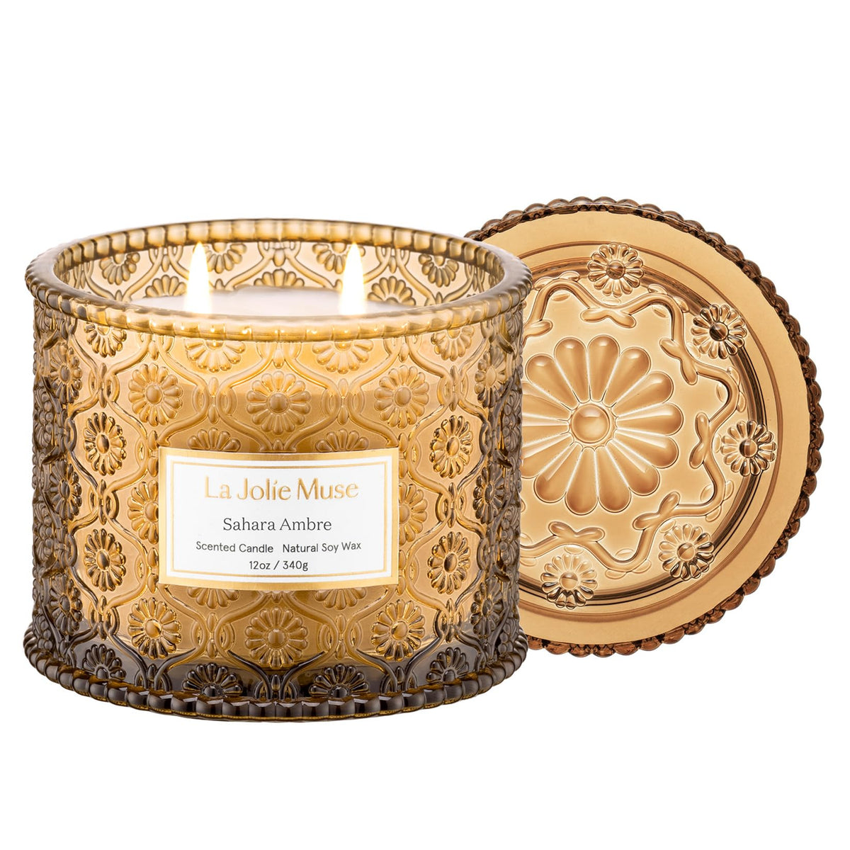 LA JOLIE MUSE Sahara Amber Candle in embossed daisy jar adds elegant decor and scent.