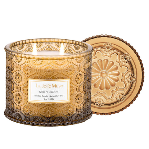 LA JOLIE MUSE Sahara Amber Candle in embossed daisy jar adds elegant decor and scent.