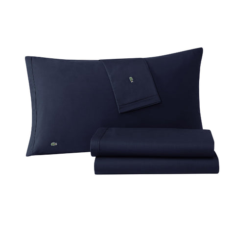 Lacoste 100% cotton percale navy flat sheet on a bed showing all-season coolness