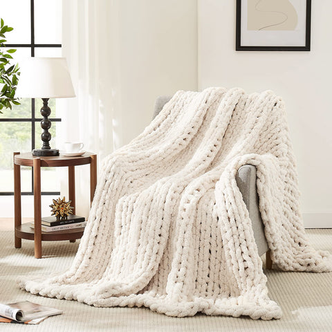 L'AGRATY ivory chunky knit blanket on a couch for cozy warmth.