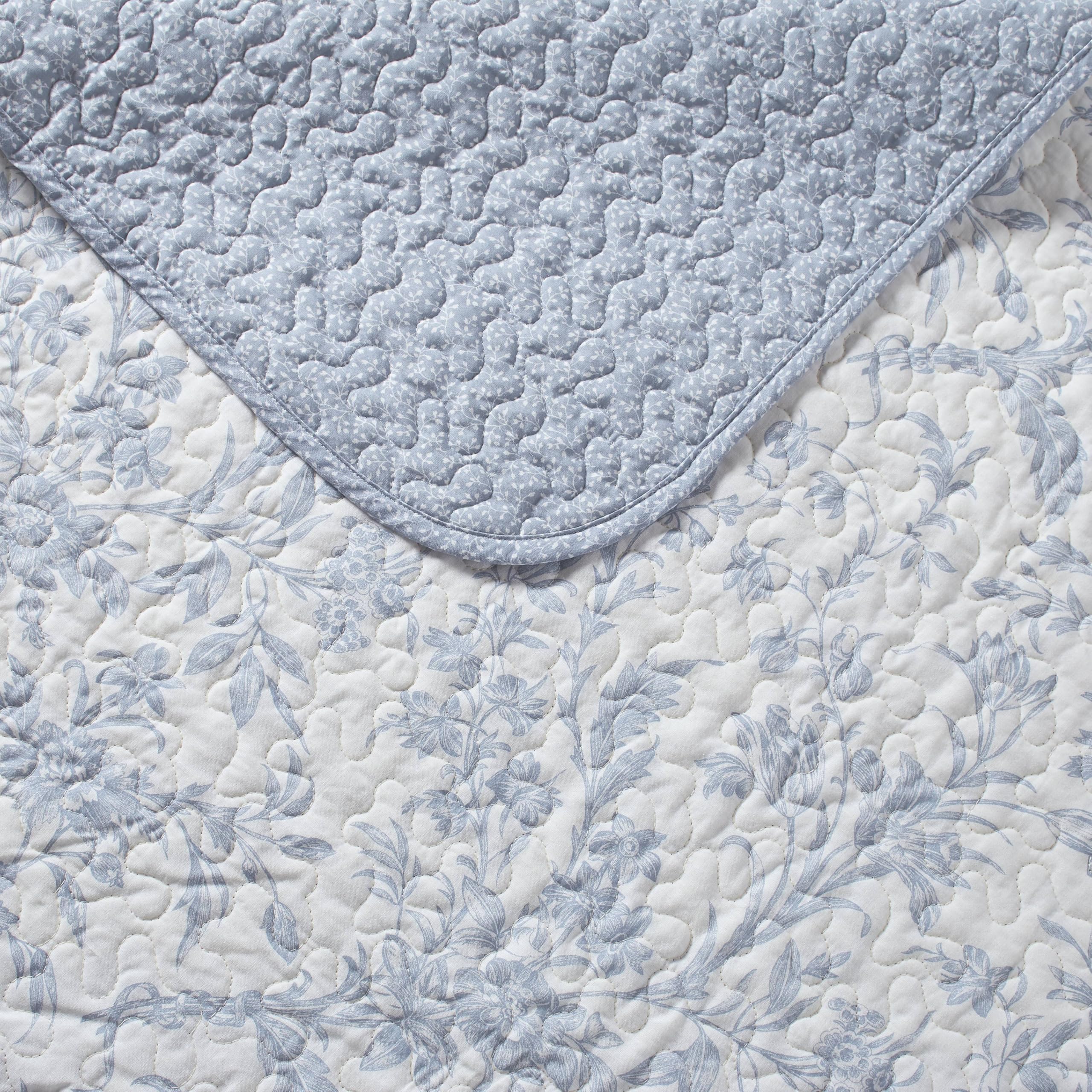 Close-up of Laura Ashley Amberley Blue quilt fabric, highlighting breathable cotton blend and refined stitching.