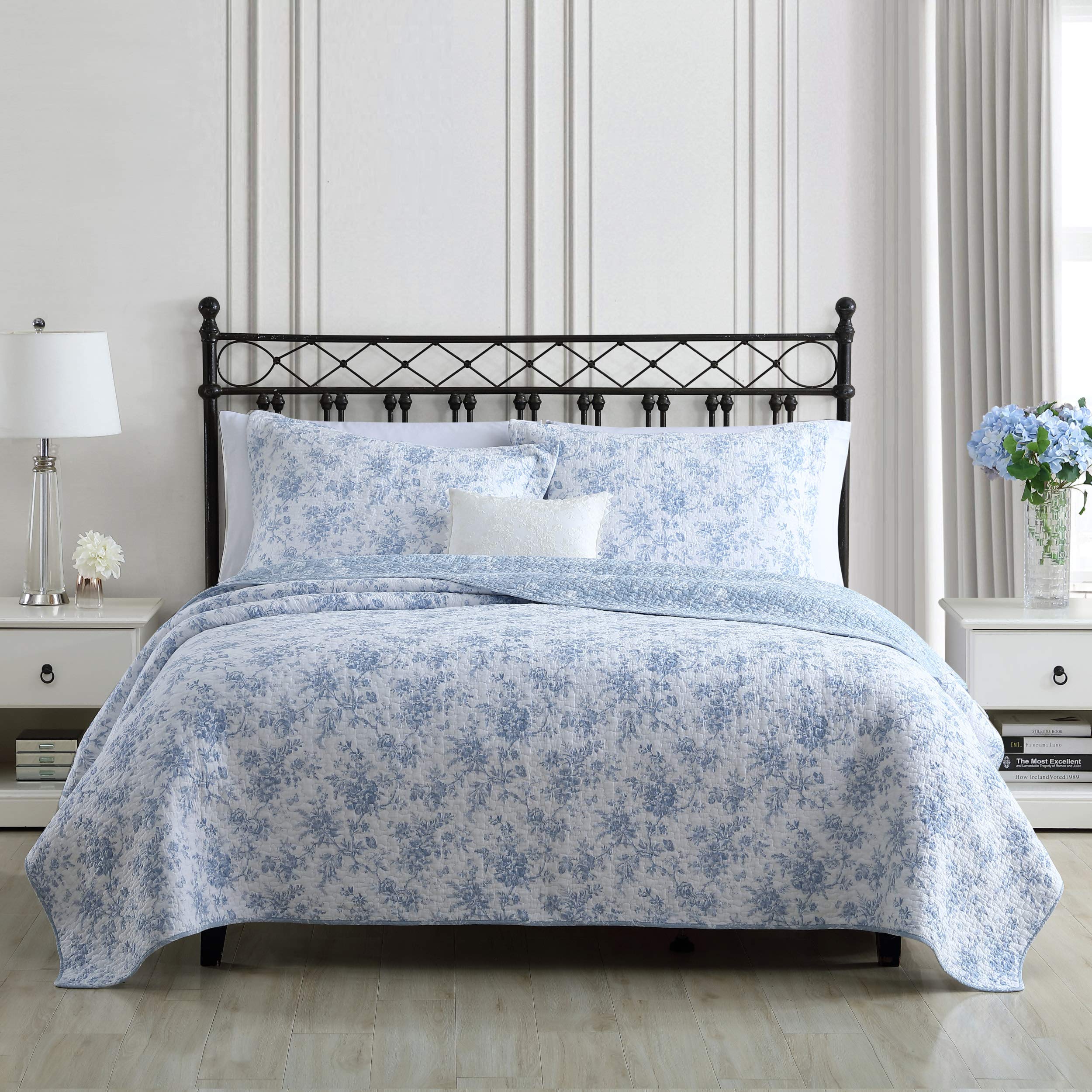 Laura Ashley Full/Queen quilt set on bed highlighting reversible design with blue floral motif