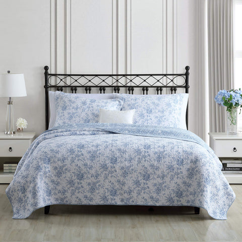 Laura Ashley Full/Queen quilt set on bed highlighting reversible design with blue floral motif
