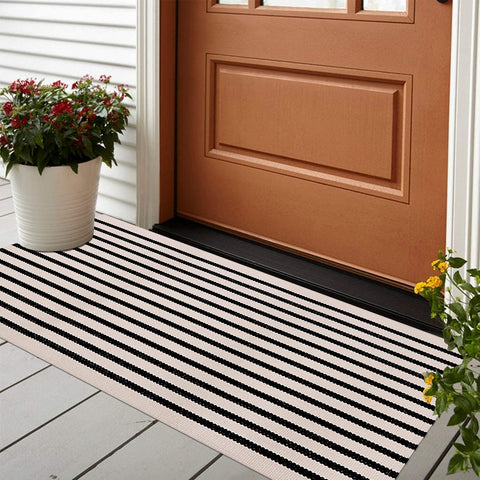 Leevan black and white striped rug front door view highlights durable outdoor use.