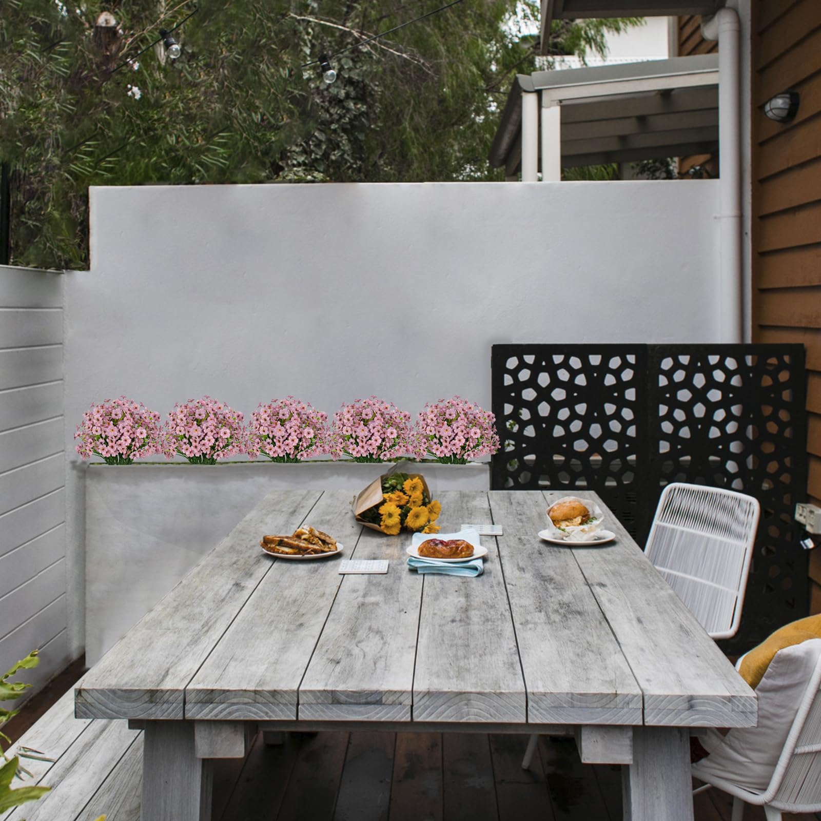 LikSoor decorative pink flowers on garden porch railing.