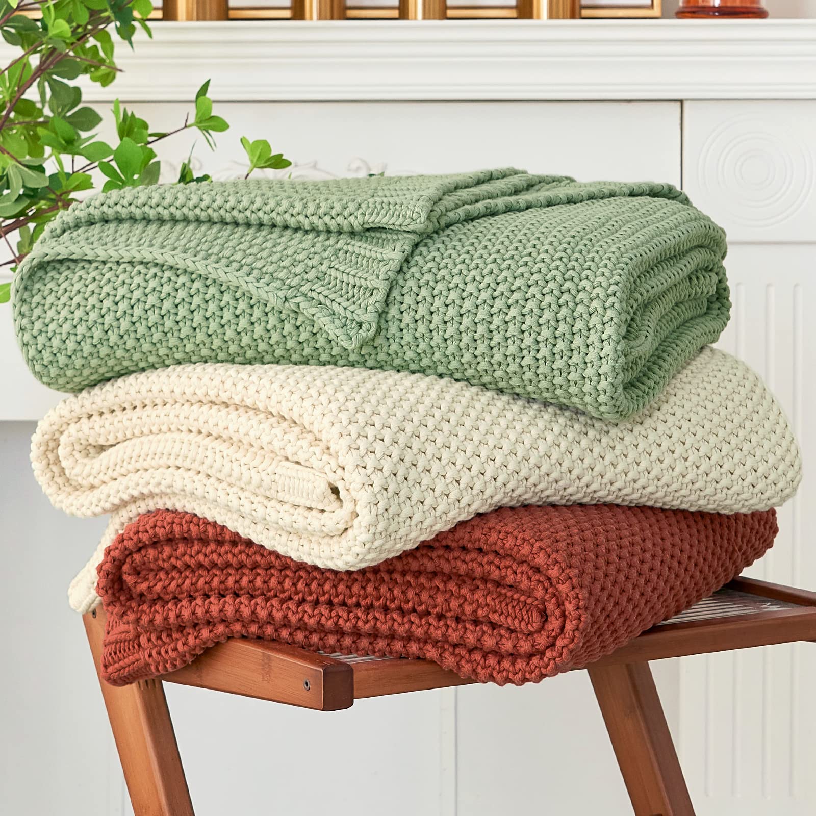 Longhui Bedding chunky cable knit throw blanket in green adds cozy warmth to a sofa.