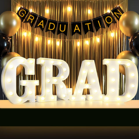 Lovelite GRAD sign four-letter set on a table centerpiece with warm glow