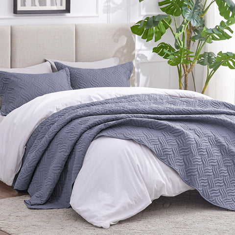Love's cabin bluish-grey bedspread complements modern queen bedroom décor.