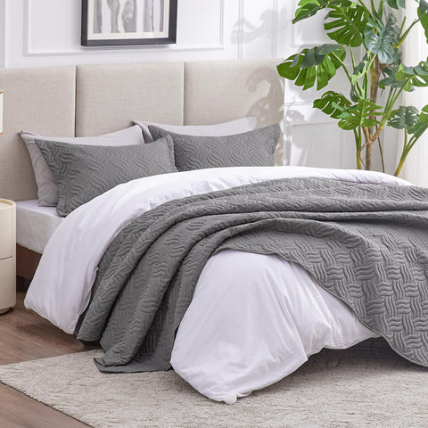 Love's cabin grey quilt on bed with matching shams full view