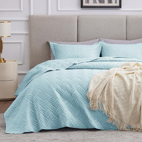 Love's cabin wave-pattern quilt in light blue adds soft texture to the bed.