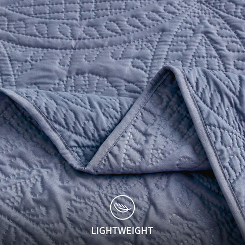Twin quilt in blue layered with an extra blanket for versatile warmth.