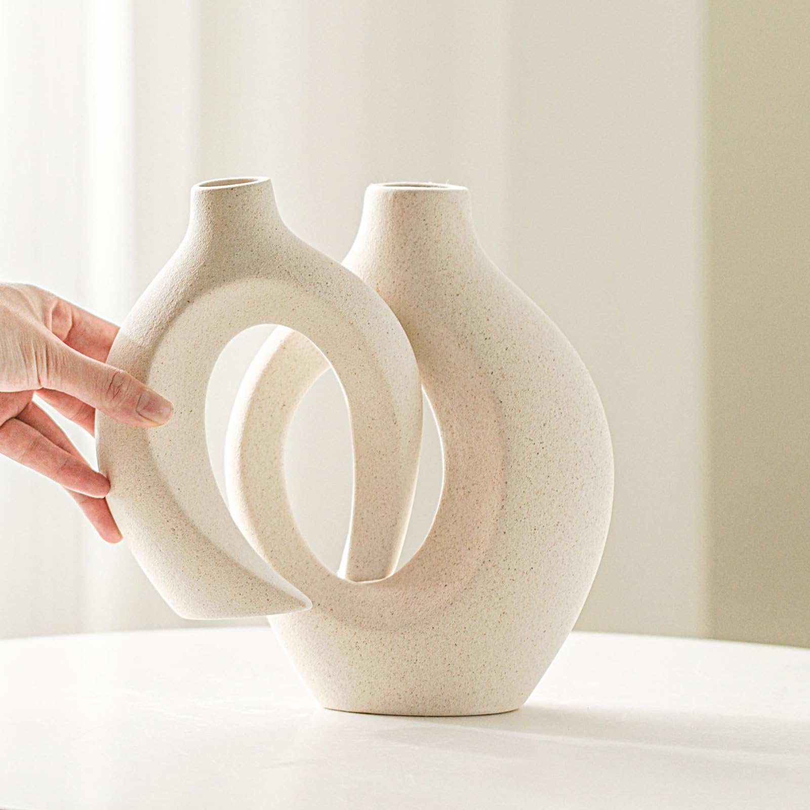 Lvases Snuggle Hollow tall milky white vase adds sculptural presence.