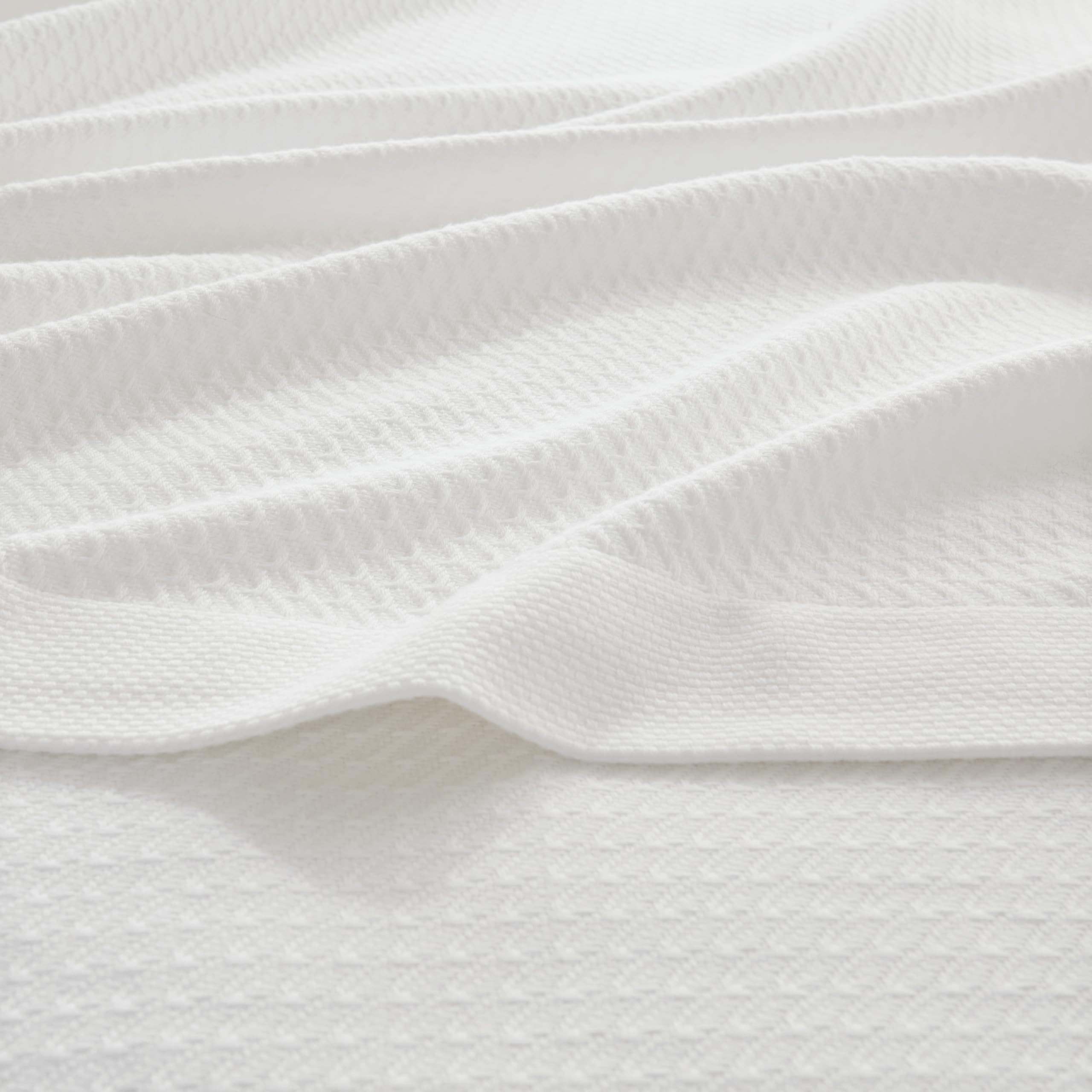 Madison Park Egyptian Cotton Blanket shown in all-season use on bed and couch.