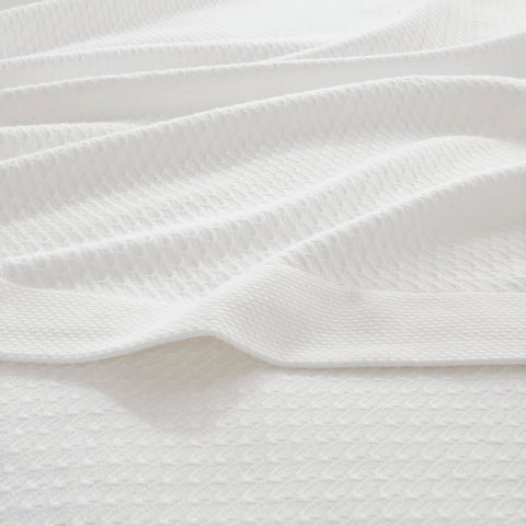 Madison Park Egyptian Cotton Blanket shown in all-season use on bed and couch.