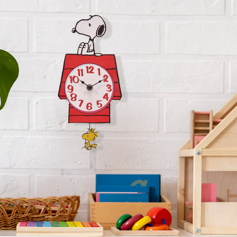 Mark Feldstein Snoopy Doghouse clock stands 12 inches, a perfect shelf or wall accent.