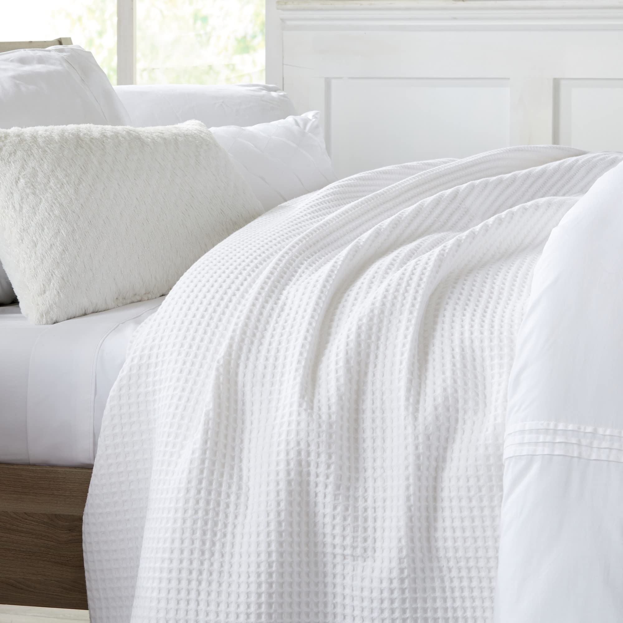 White Brielle blanket draped over a bed with a crisp, clean look