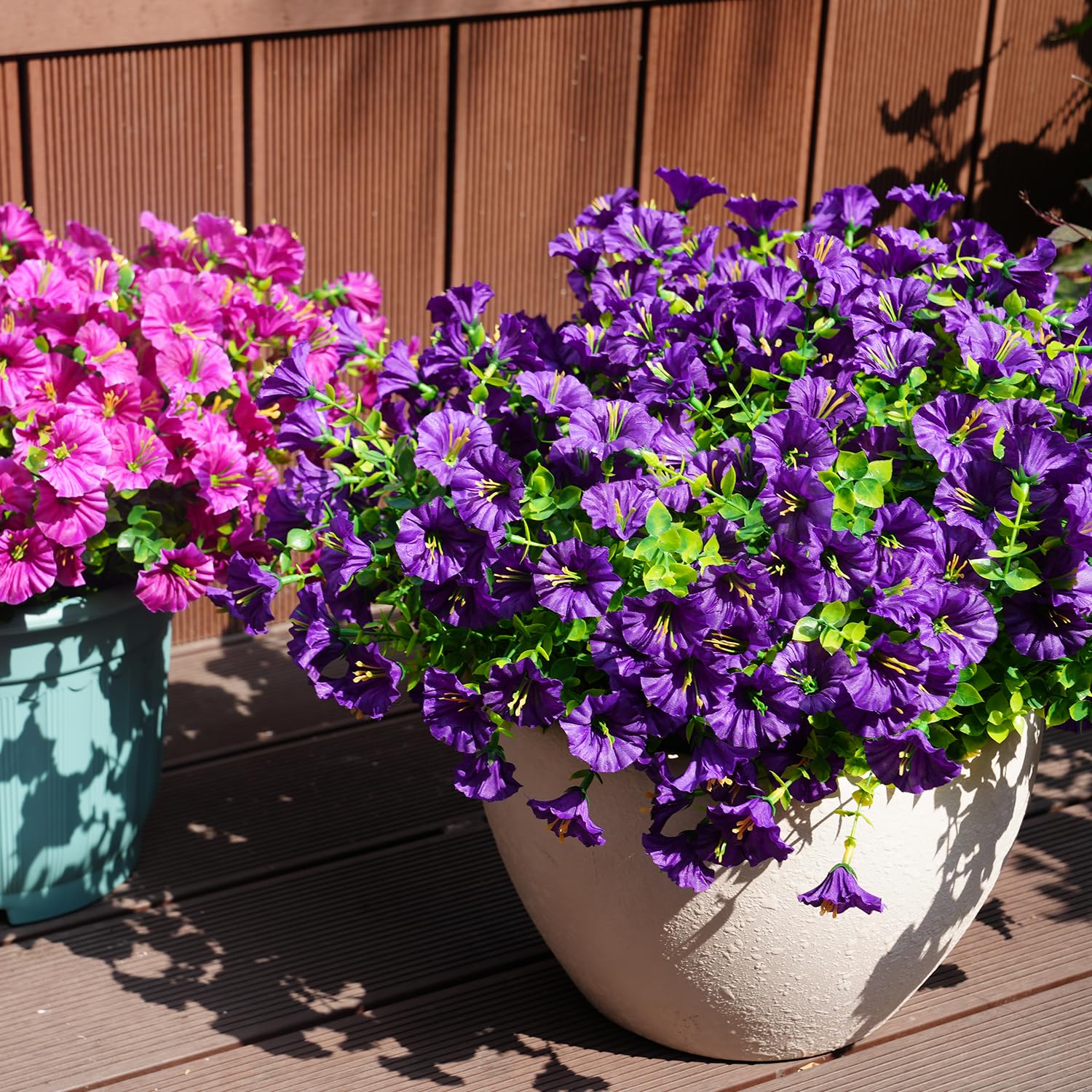 Maxkes patio hanging planters showcase faux flowers.