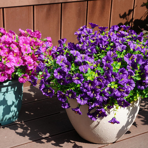 Maxkes patio hanging planters showcase faux flowers.