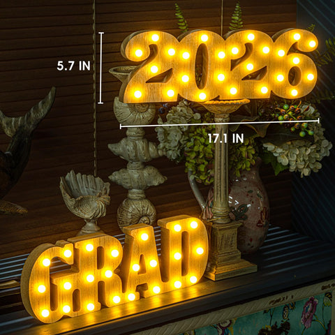 Meadin Grad 2026 LED letters brighten a desk display at a ceremony