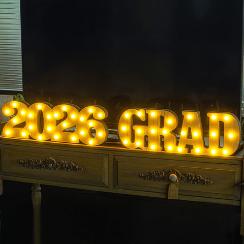 Meadin Grad 2026 LED letters stand on a podium for collegiate celebrations