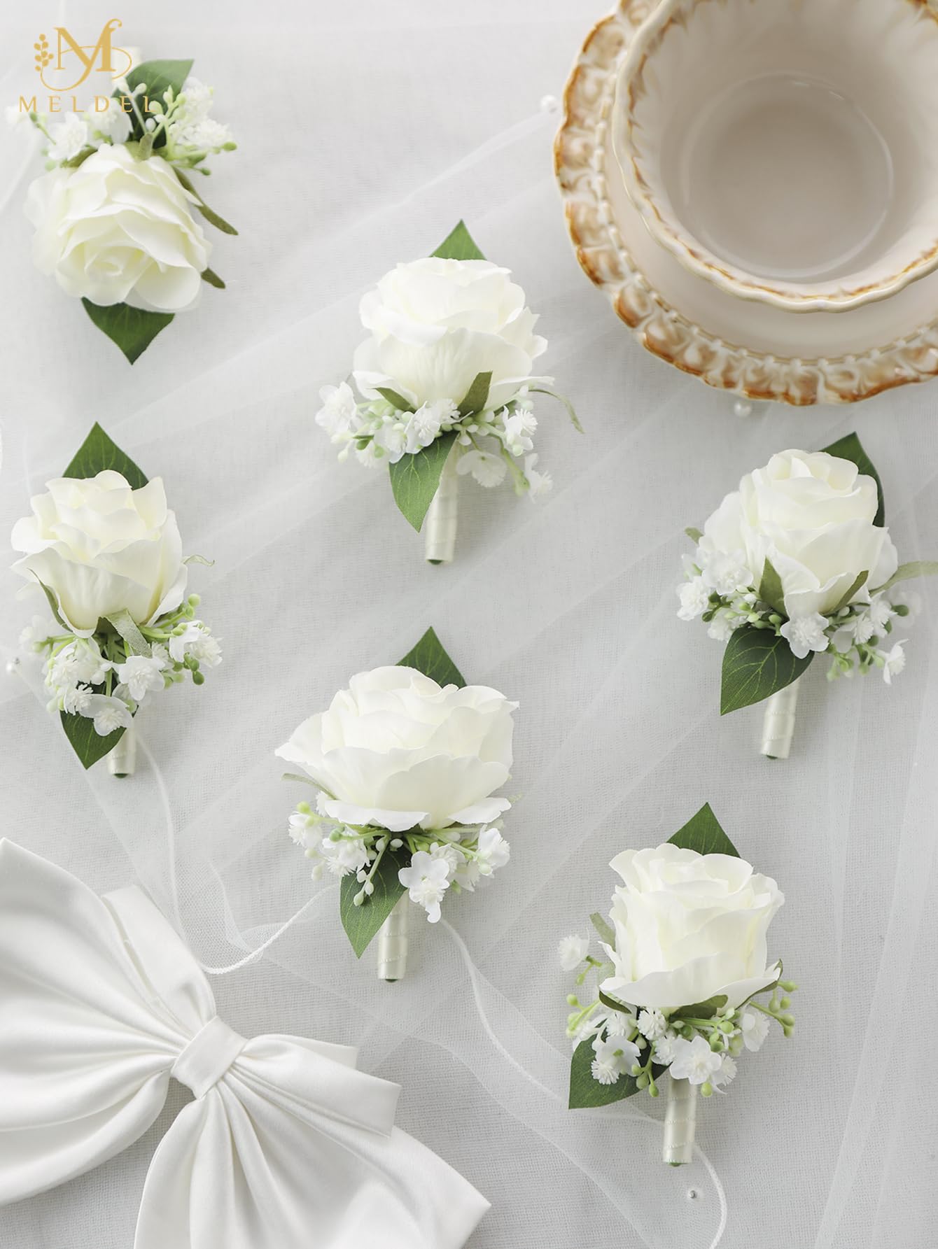 Six piece Meldel white boutonniere set ready to wear for weddings and events.