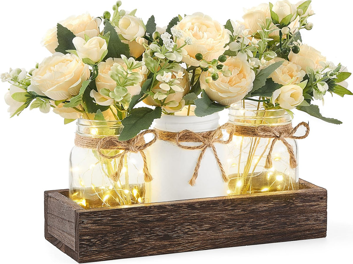 Mkono mason jar lights centerpiece on wooden box for warm dining table ambiance.
