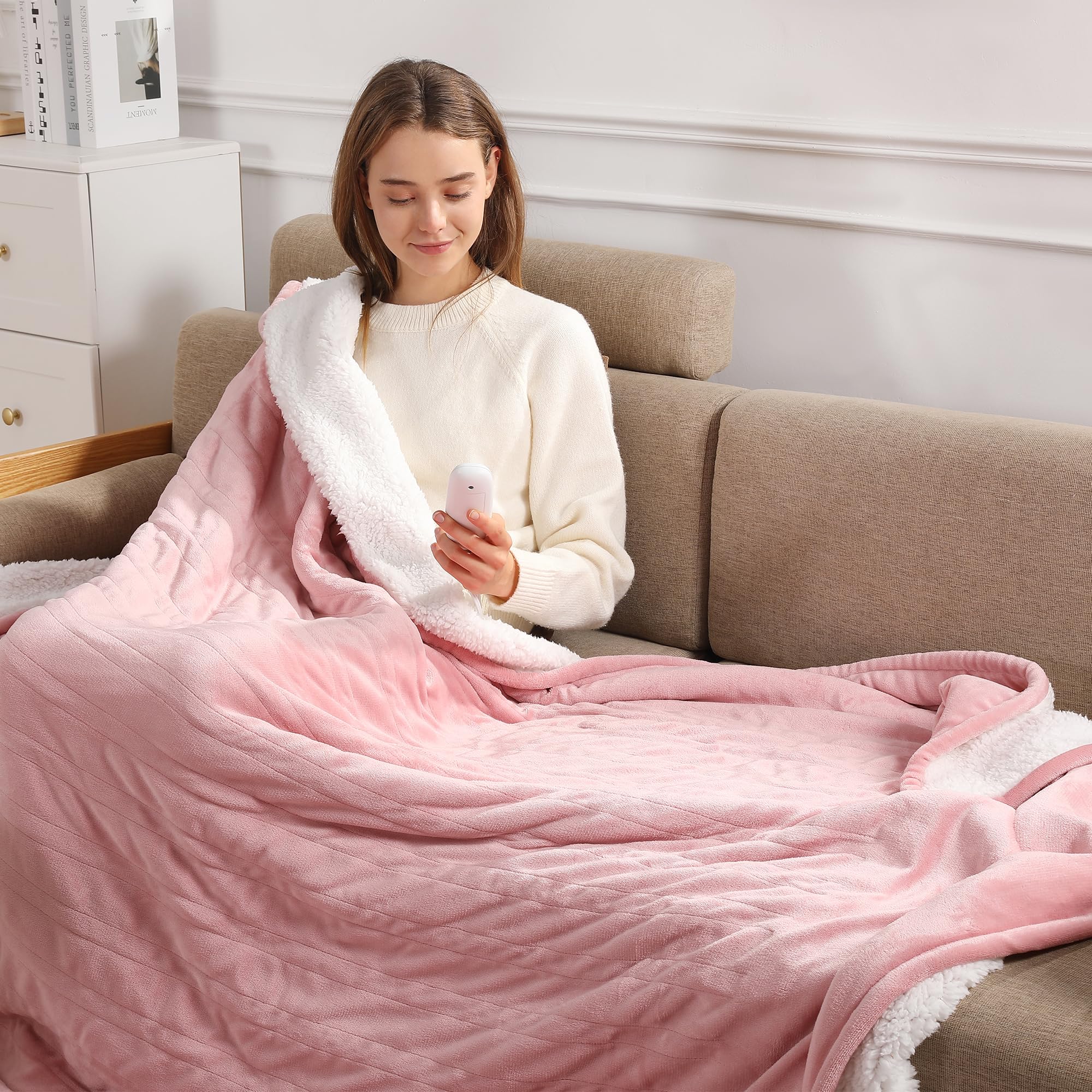 Molatink heating blanket in rose pink folded on a sofa for instant cozy warmth