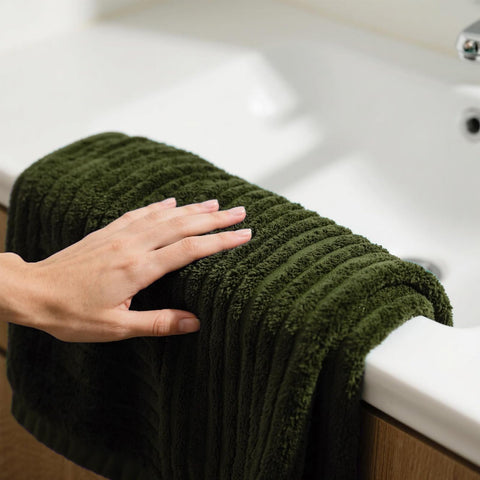 NALIVO microfiber fibers absorbing water quickly in olive green bath sheet.
