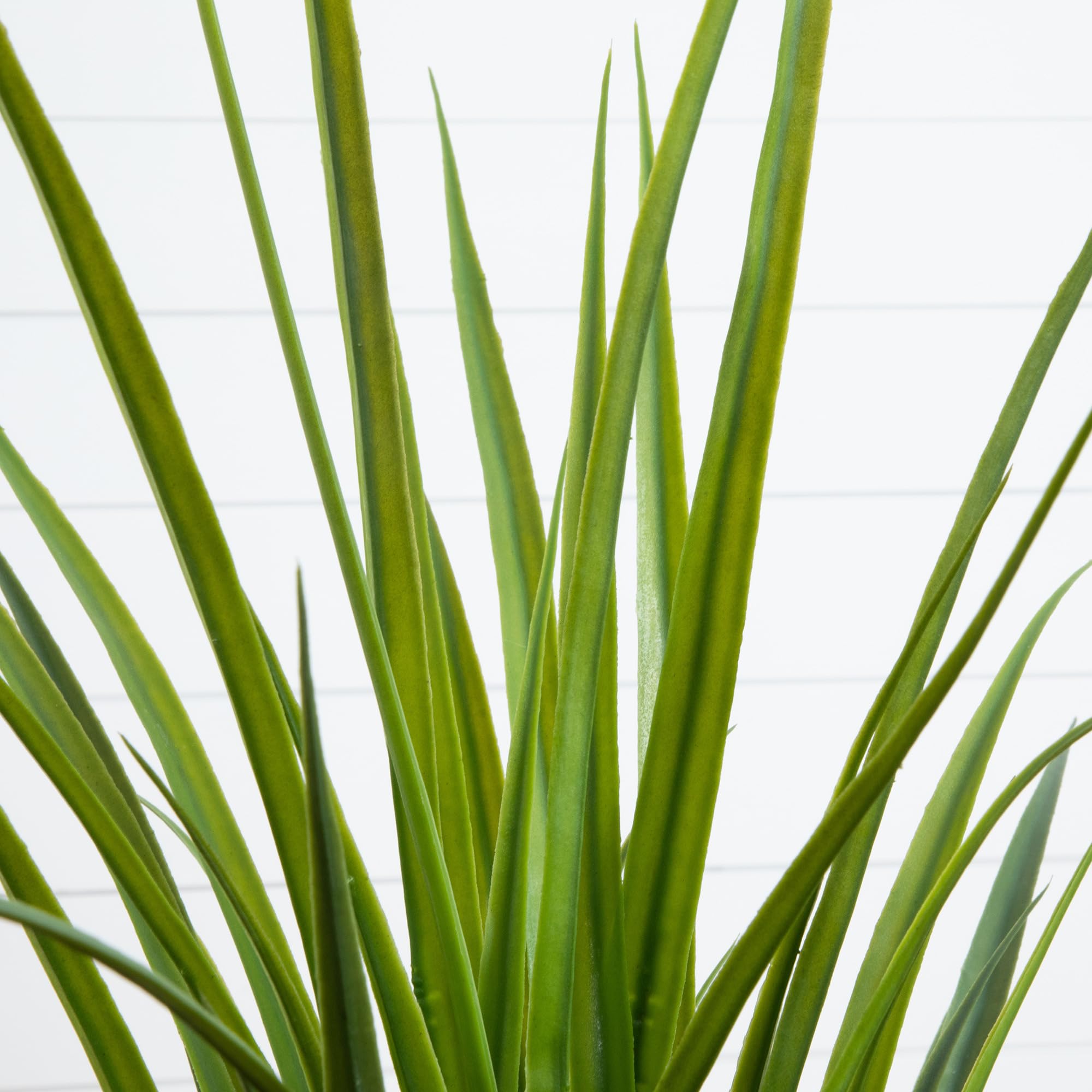 Nearly Natural 4ft artificial grass plant closeup leaves show lifelike texture.
