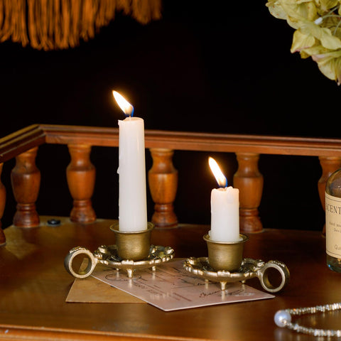 NIKKY HOME vintage metal candlesticks on a mantel with warm glow.