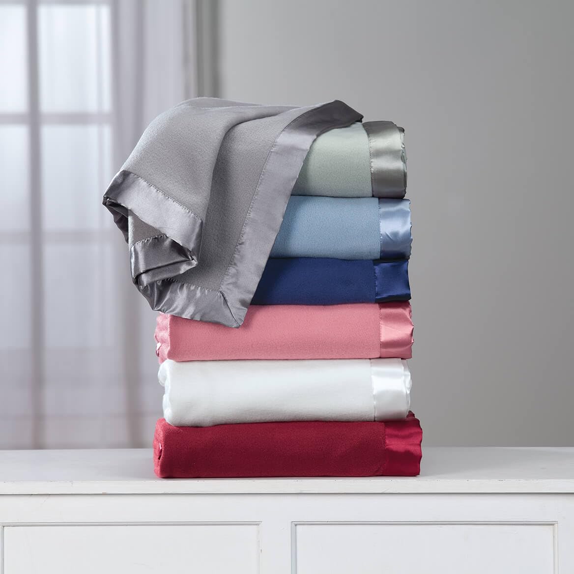 OakRidge satin fleece blanket displayed on bed for versatile comfort