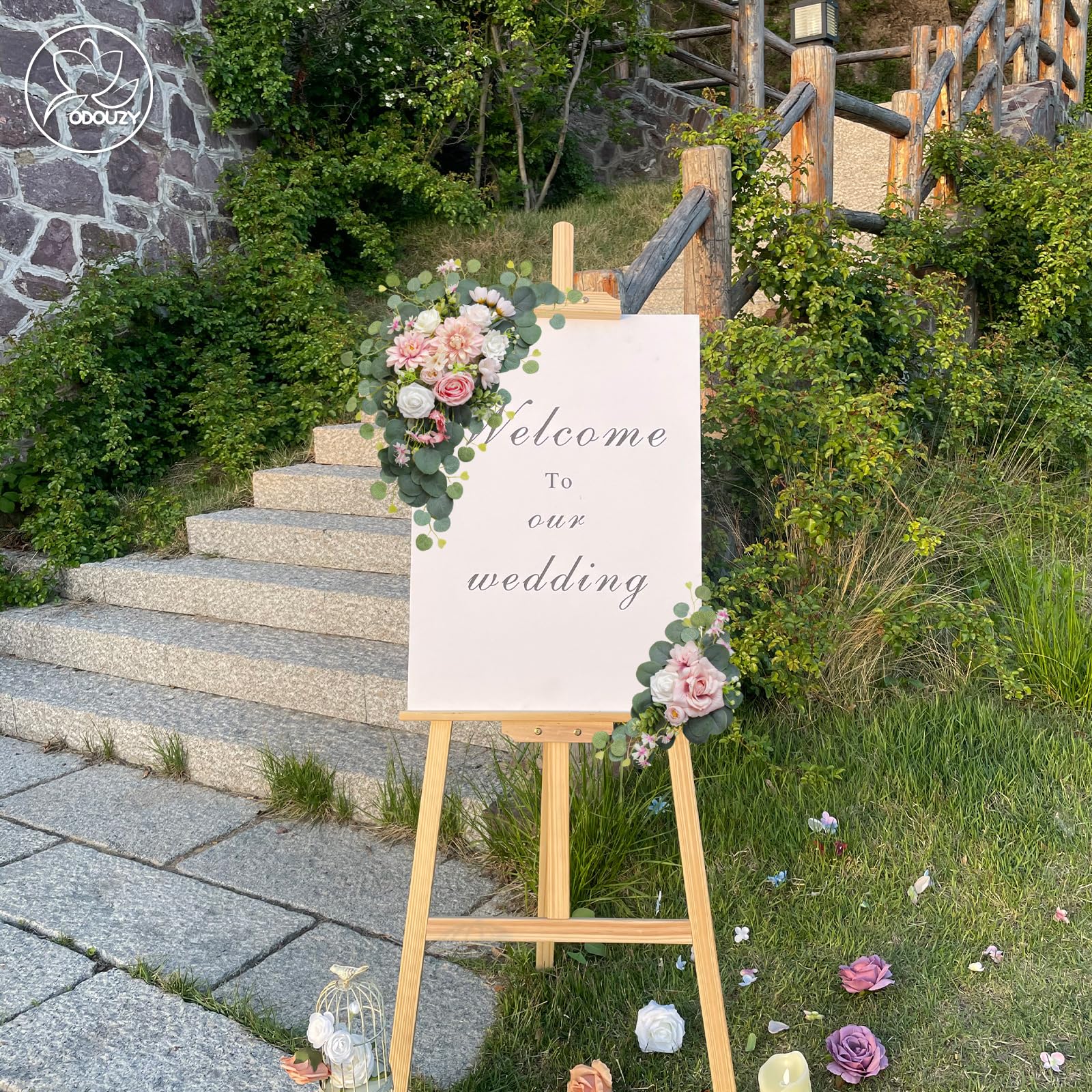 Odouzy pink flower swag enhances signage while offering reusable keepsake potential.