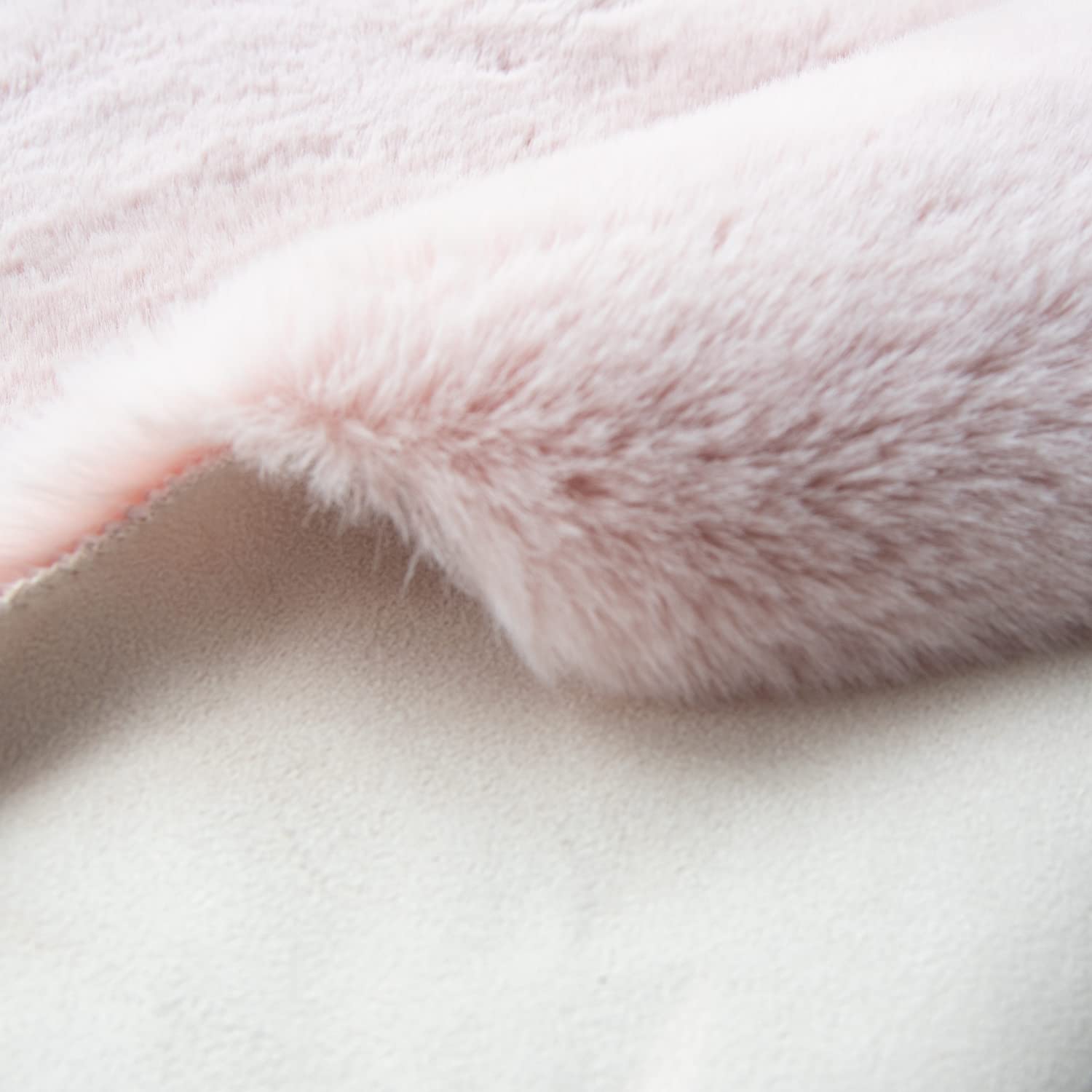 ORINOVA faux rabbit fur rug beside nursery crib adds gentle comfort.