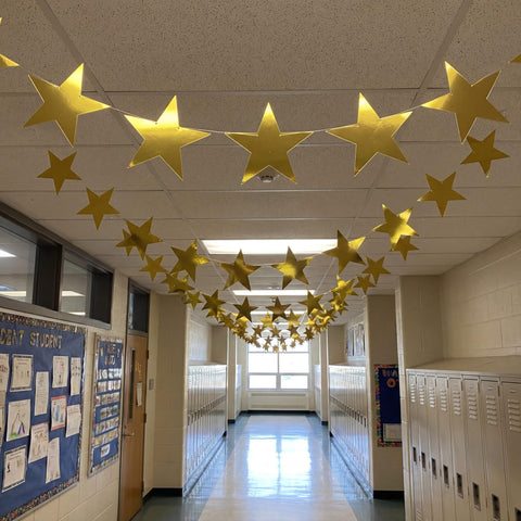 Outus gold star wall decor enhances classroom or party spaces.