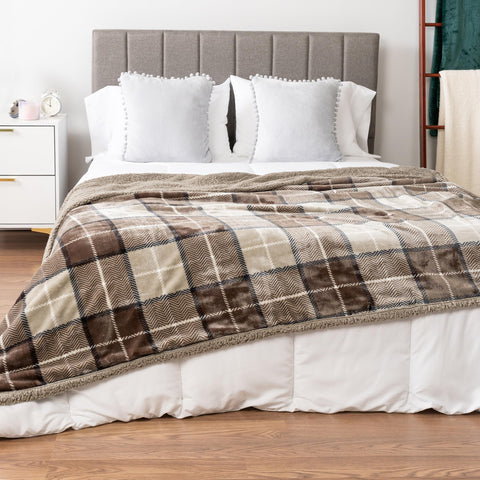 PAVILIA taupe plaid sherpa blanket draped on bed for elegant texture.