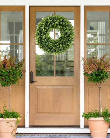 Petalyn boxwood wreath hanging on door for instant curb appeal.