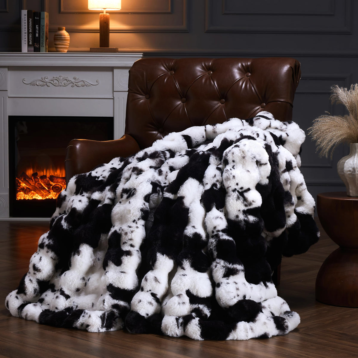 PLUUSHUU faux fur throw cow print black enhances sofa comfort and style.