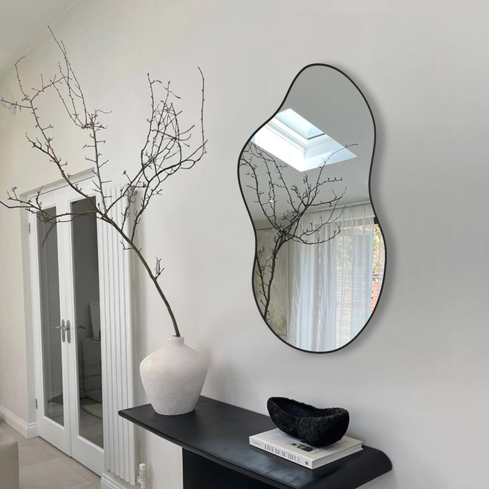 Potijo modern asymmetrical mirror in black frame enhances entryways with visual interest.