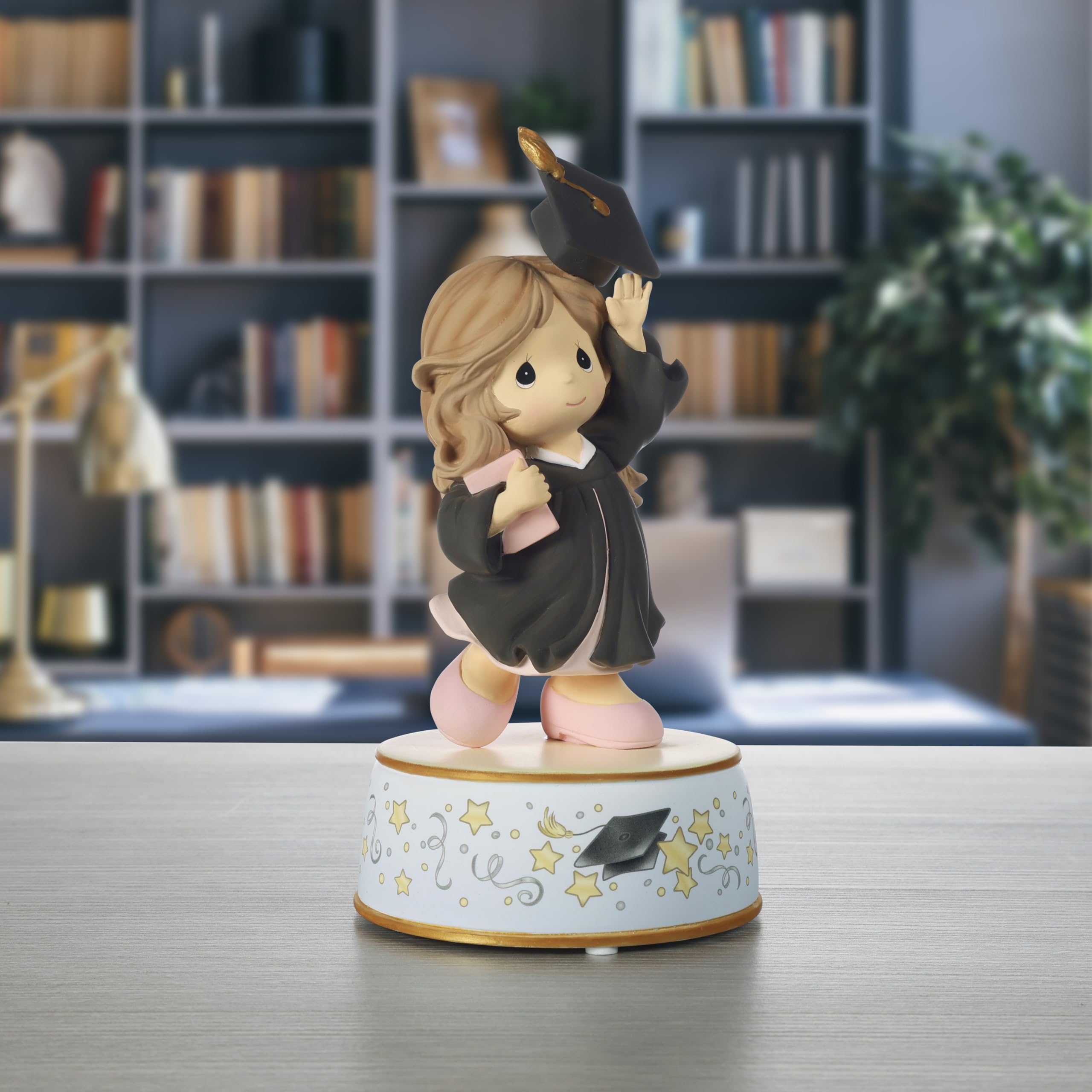 Precious Moments brunette graduate in black gown, a refined keepsake for commemorating achievement.