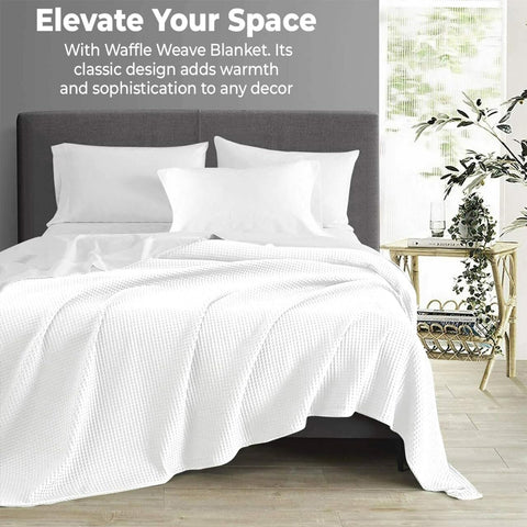 QUBA LINEN waffle blanket on bed draped in white for easy elegance.
