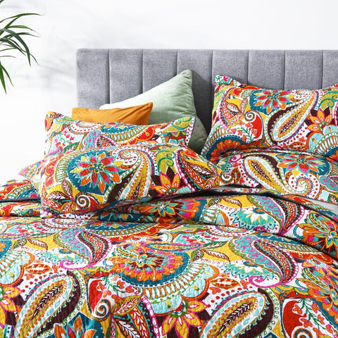 Qucover California king quilt in vibrant colors brightens a room.