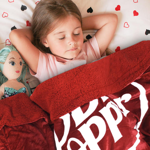 RMKA Dr Pepper blanket on sofa showing plush texture and bold color