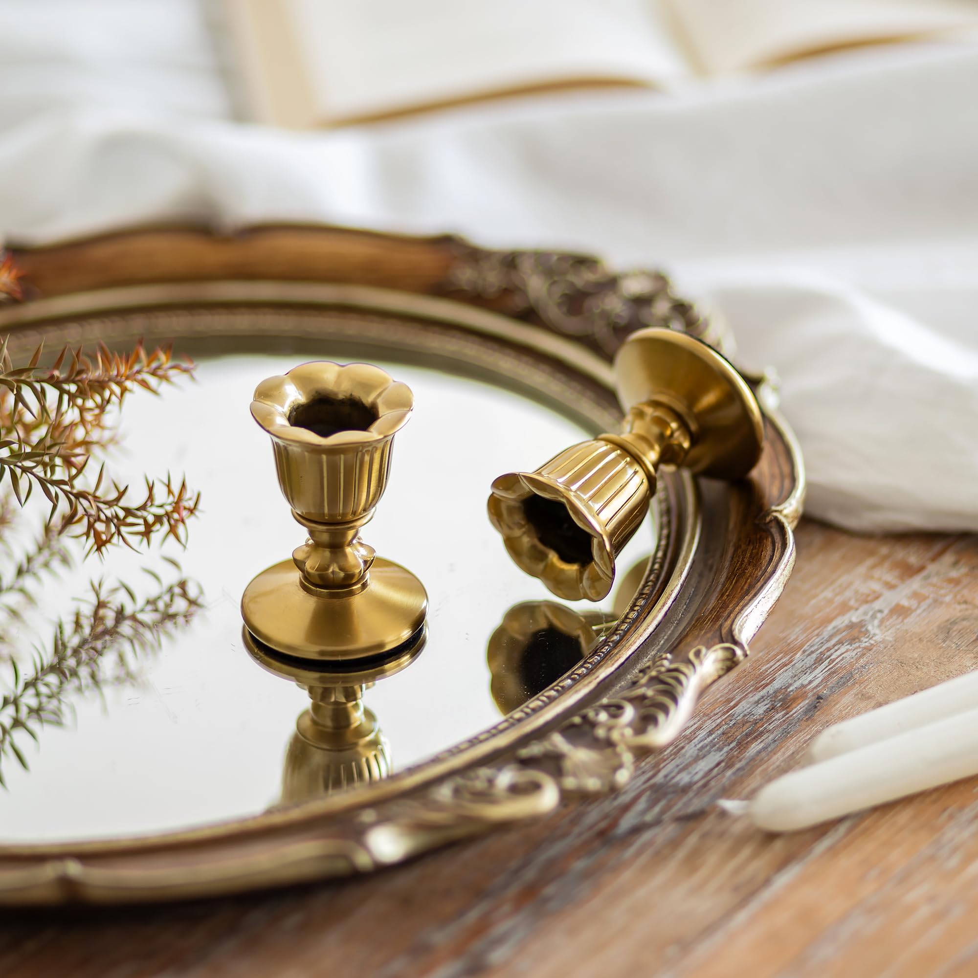 Romadedi gold taper candle holder on a mantel, showcasing Victorian style.