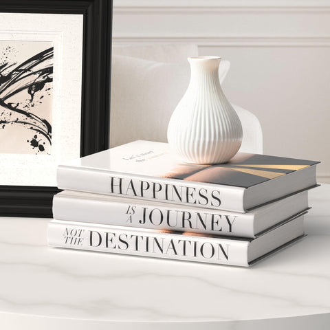 Roomicle decorative books stacked on a coffee table for chic ambience.