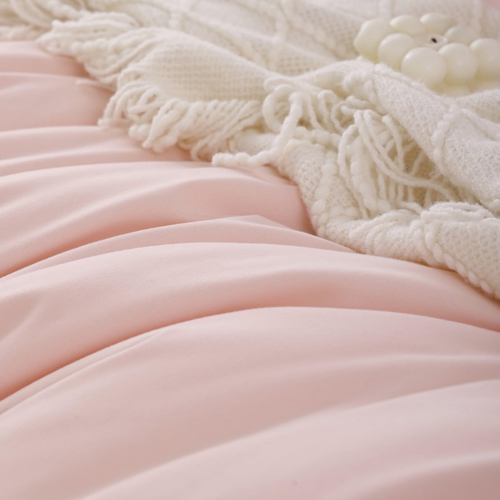 ROSGONIA bed draped with blush comforter on a tidy dorm bed.