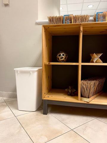 Rectangular Rubbermaid trash can fits neatly beside toilet and cabinet in tight spaces.