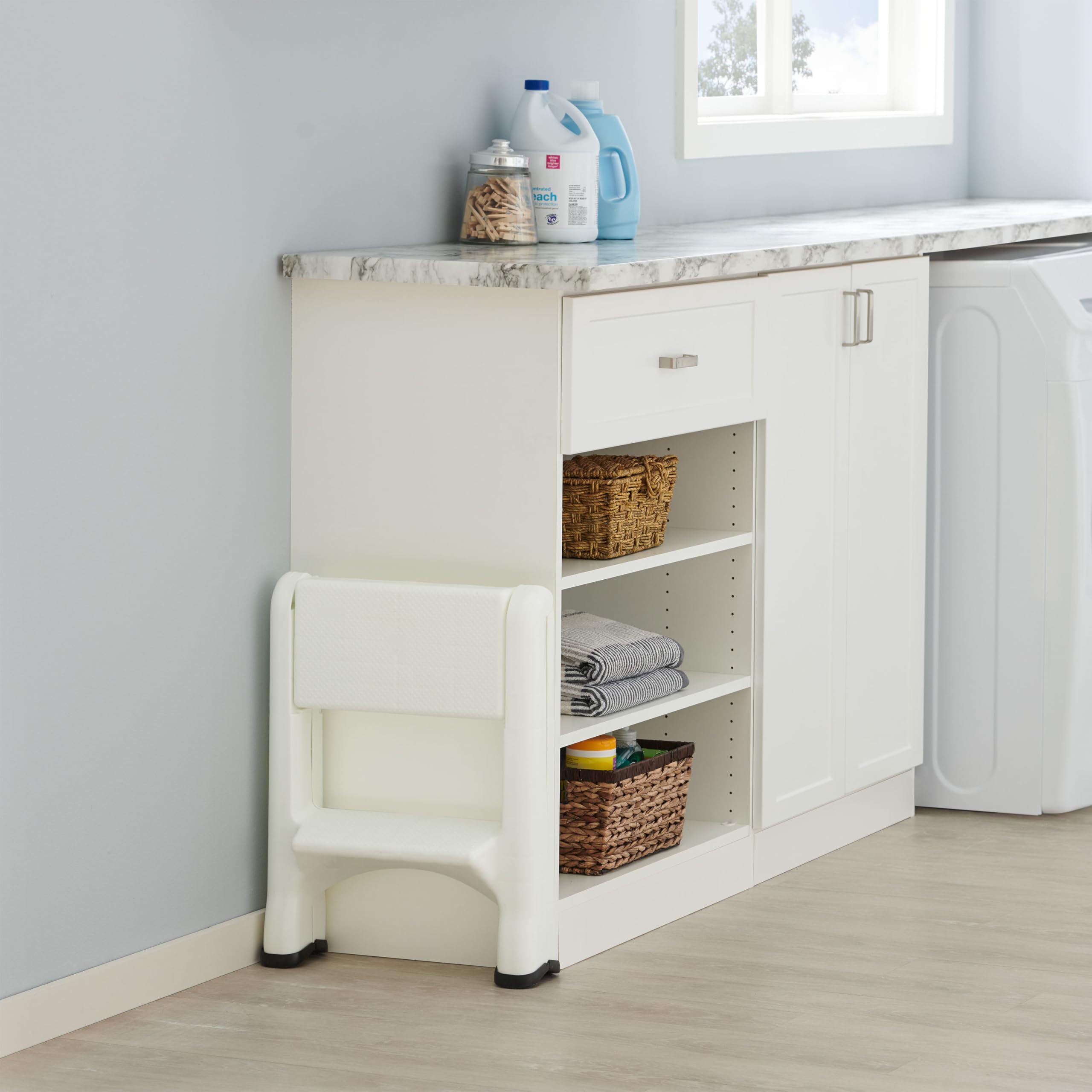 Rubbermaid step stool in garage use for accessing tools and shelves.