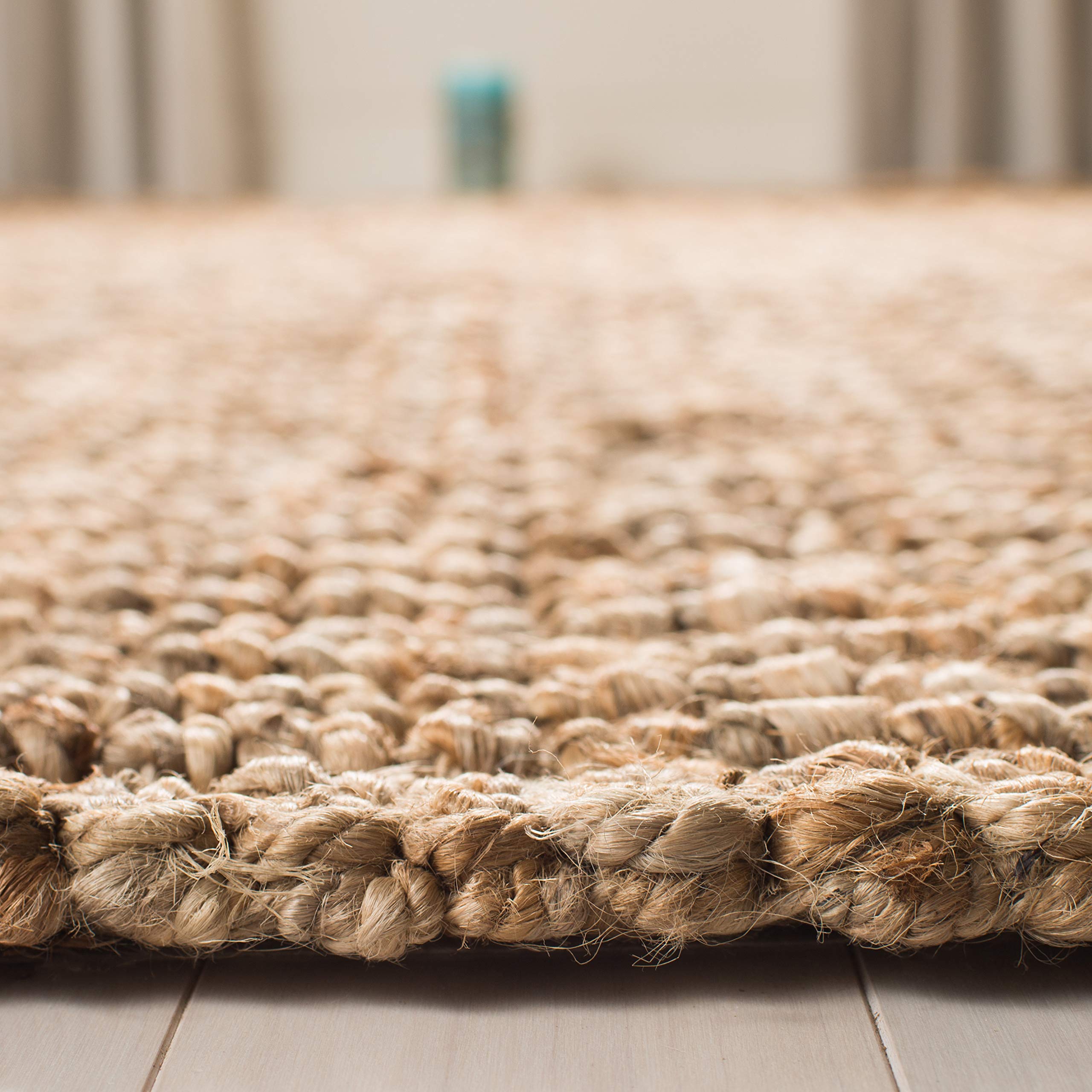 SAFAVIEH dining area setup features durable jute rug under table.